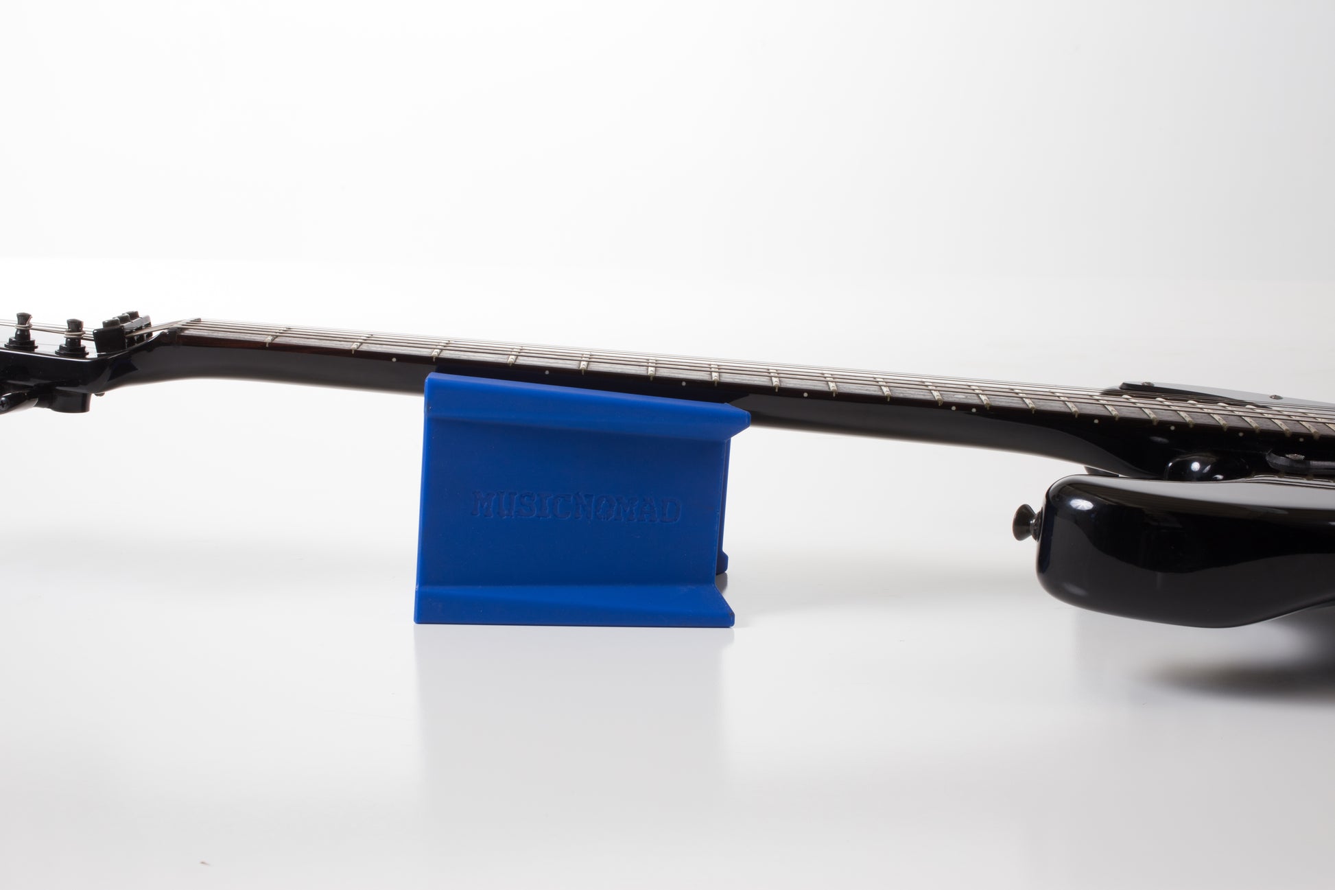 MUSIC NOMAD MN206 CRADLE CUBE ELECTRIC GUITAR RESTING IN CRADLE CUBE SIDE VIEW ON WHITE BACKGROUND