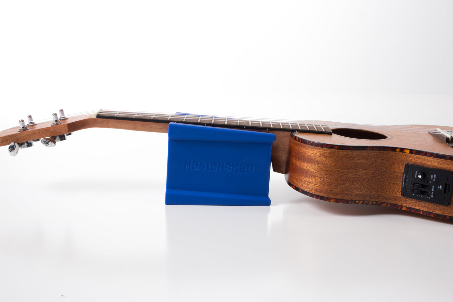 MUSIC NOMAD MN206 CRADLE CUBE UKE RESTING IN CRADLE CUBE SIDE VIEW ON WHITE BACKGROUND.
