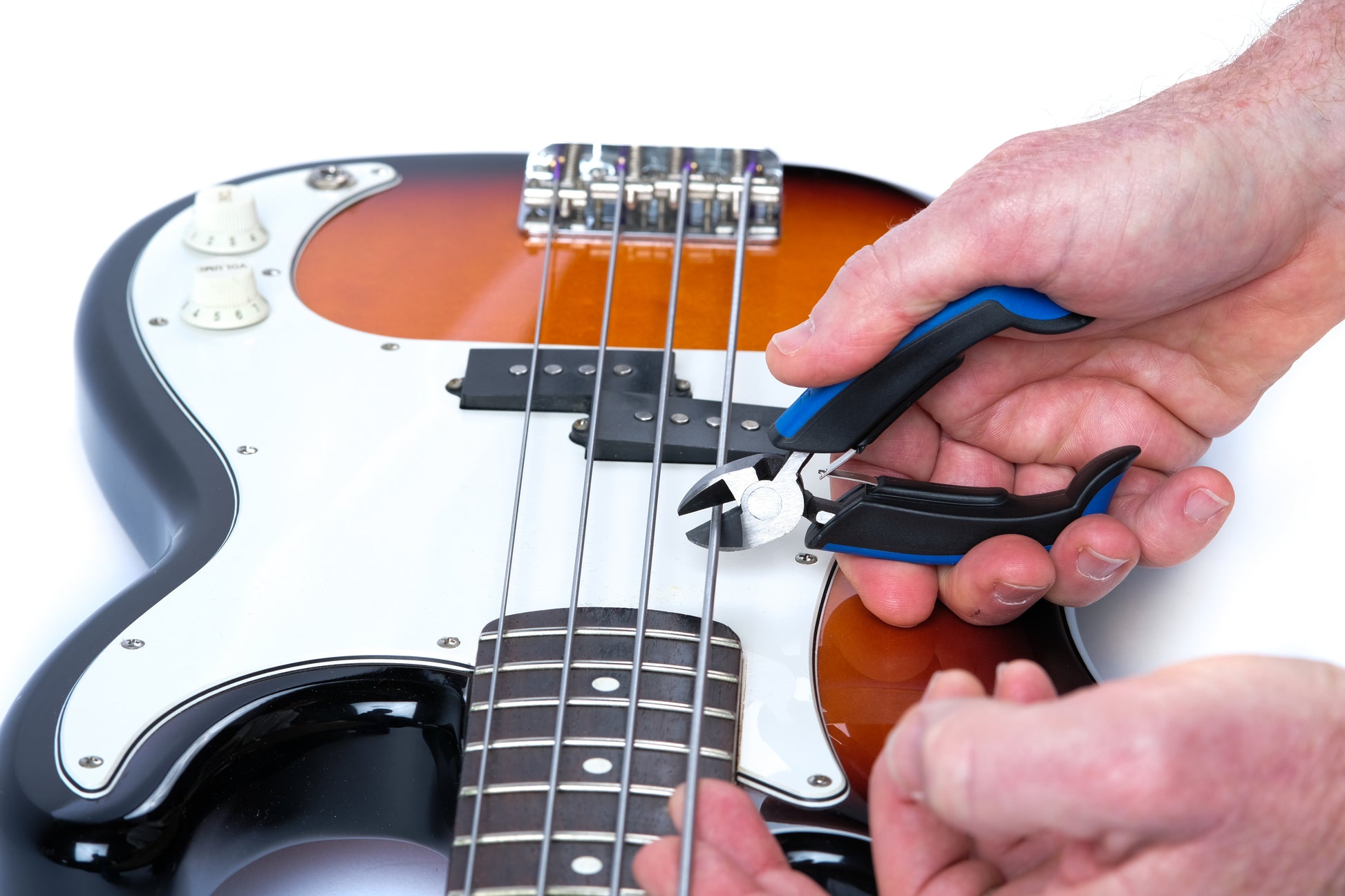 MUSIC NOMAD MN226 MUSICNOMAD GRIP CUTTER DEMO PHOTO HAND CUTTING STRING ON ELECTRIC BASS ON WHITE BACKGROUND