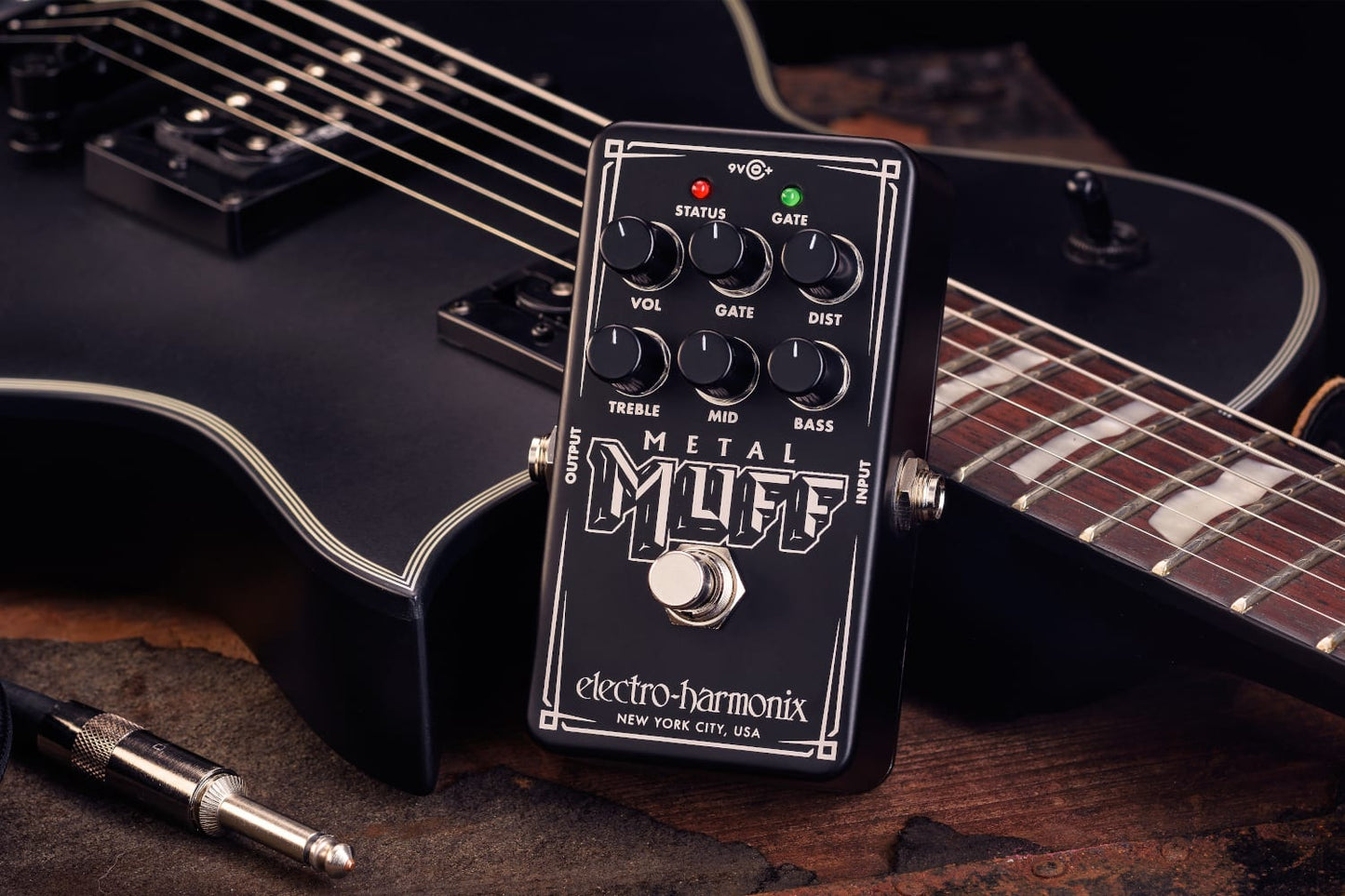 ELECTRO-HARMONIX EHX NANO METAL MUFF PROMO IMAGE FRONT SIDE VIEW WITH A BLACK GUITAR