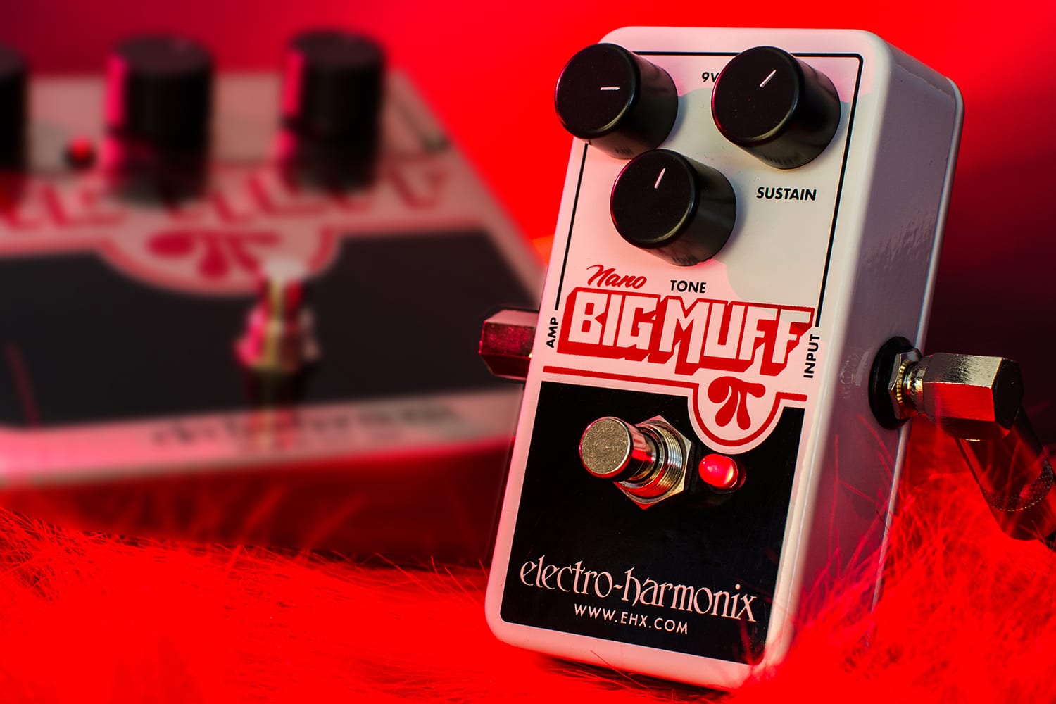 ELECTRO-HARMONIX EHX NANO BIG MUFF PI  OFFICIAL STUDIO IMAGE RED FUZZY BACKGROUND FRONT AND LEFT VIEW